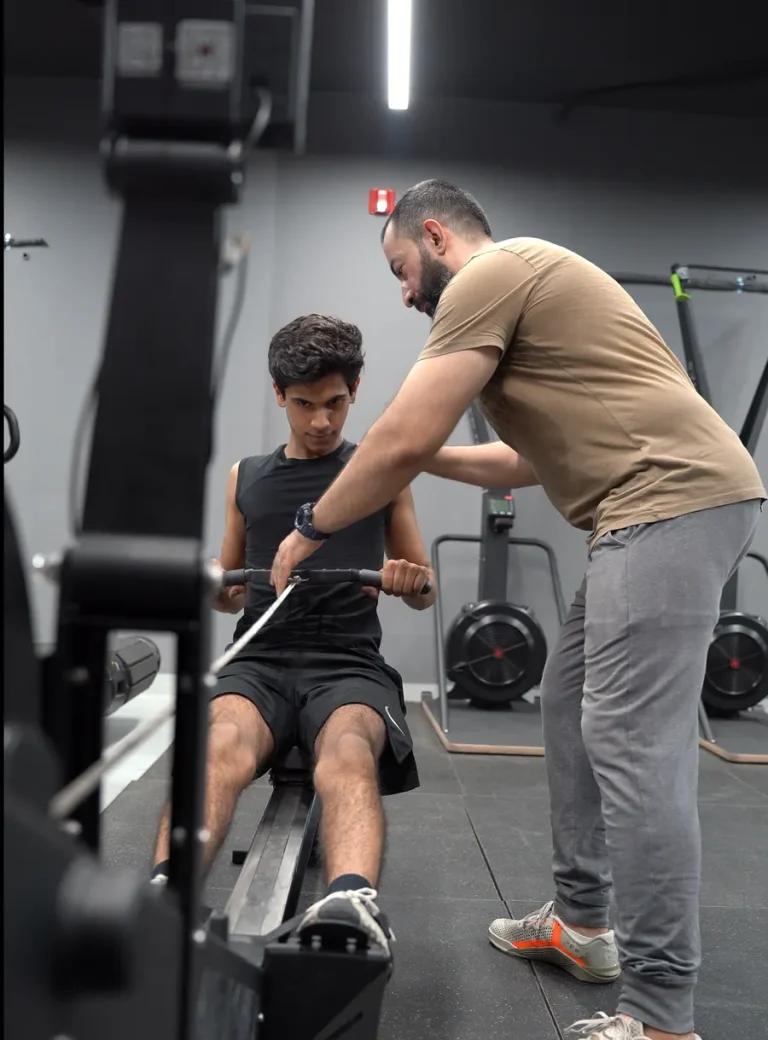Coach correcting a member’s form on a cable row at Fitnation Gym