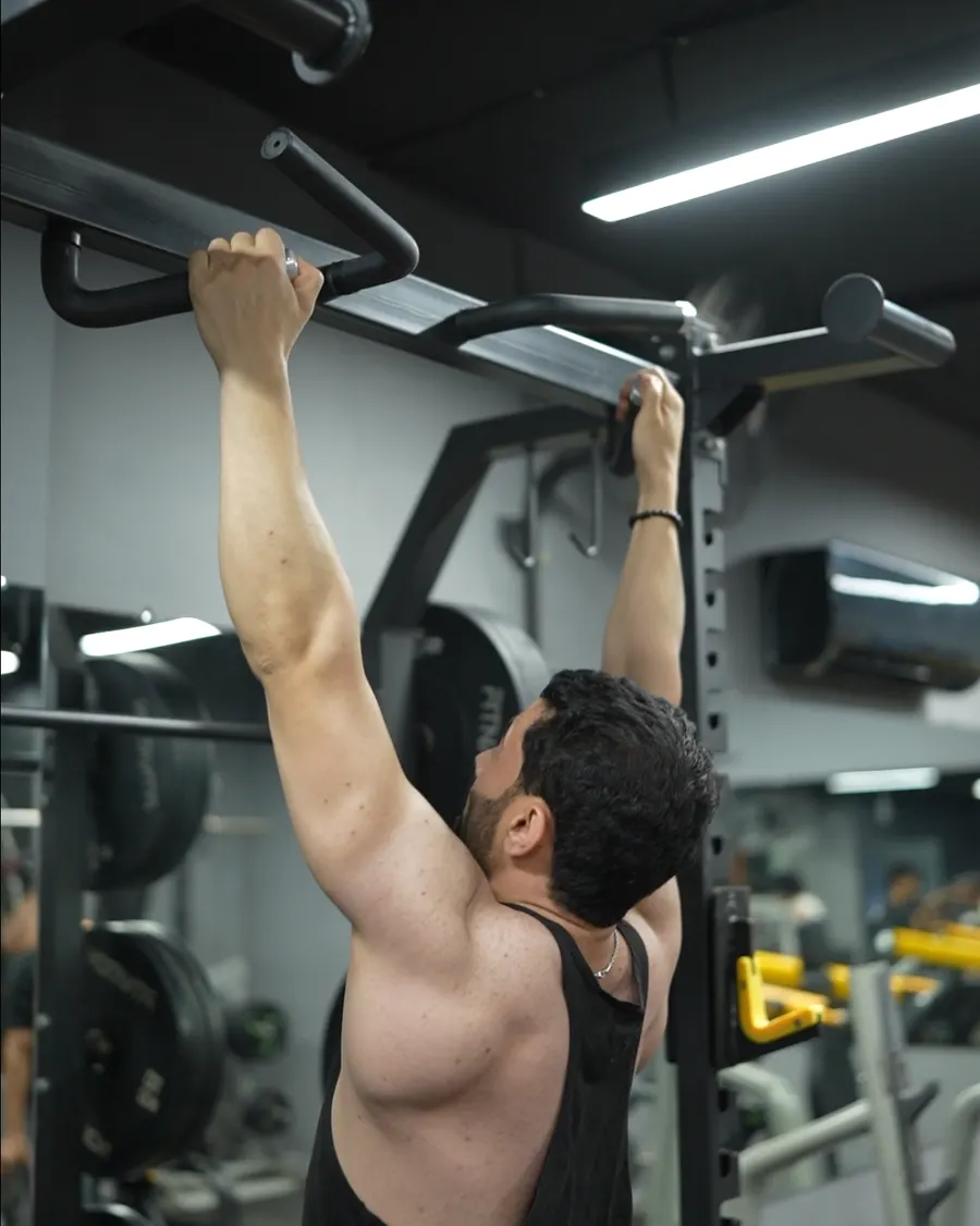 Member hanging from the pull-up bar at Fitnation Gym